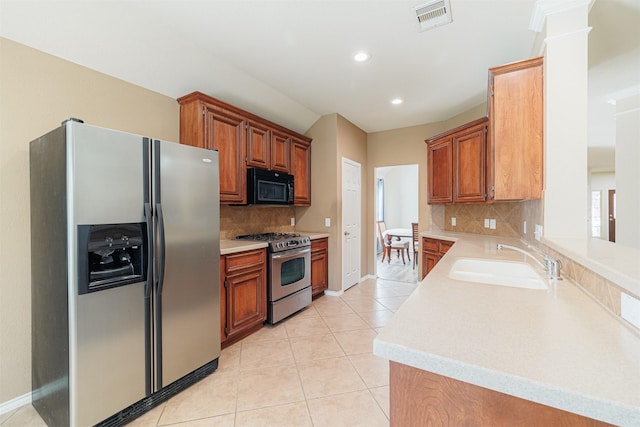 kitchen with decorative columns, light tile patterned floors, visible vents, appliances with stainless steel finishes, and a sink