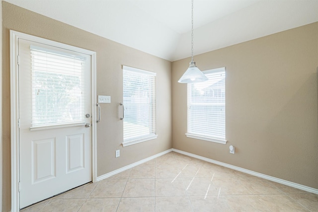 interior space with lofted ceiling, baseboards, and light tile patterned floors