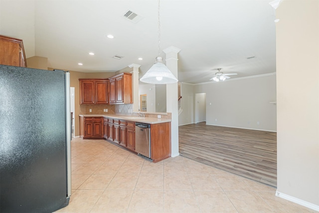 kitchen with light tile patterned floors, light countertops, backsplash, freestanding refrigerator, and dishwasher