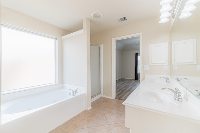 bathroom featuring tile patterned flooring, a sink, visible vents, a bath, and a stall shower