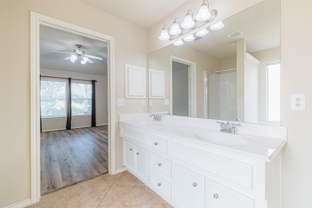 full bathroom featuring double vanity, a shower, tile patterned flooring, and a sink