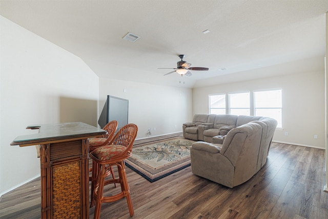 living area featuring baseboards, visible vents, and wood finished floors