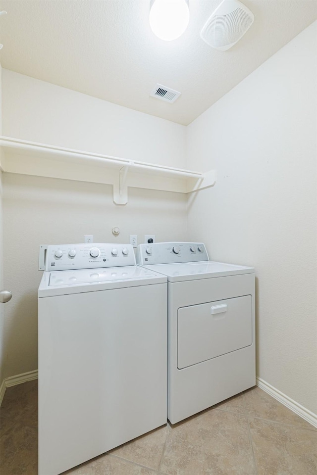 laundry area featuring laundry area, baseboards, visible vents, and washing machine and clothes dryer