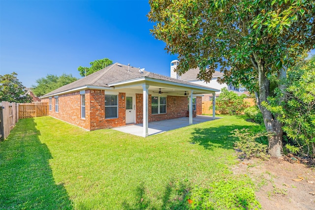 rear view of house featuring a lawn, a ceiling fan, a patio, a fenced backyard, and brick siding