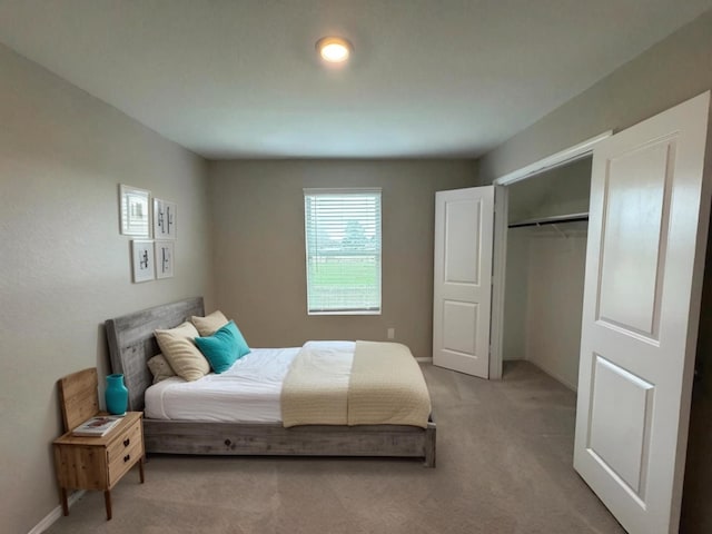 bedroom with a closet, light carpet, and baseboards