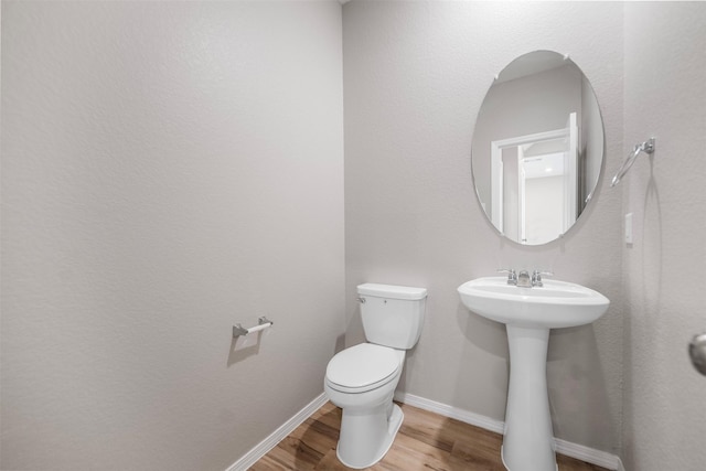 23947 Falling Daylight Dr, Hockley, TX 77447 - half bath featuring wood finished floors, toilet, baseboards, and a sink