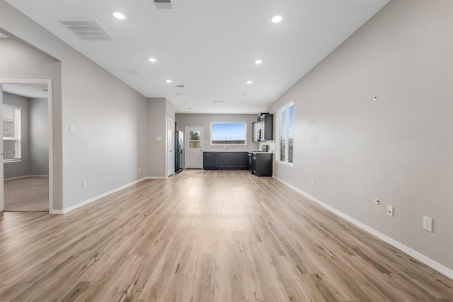 23947 Falling Daylight Dr, Hockley, TX 77447 - unfurnished living room featuring light wood finished floors, baseboards, and recessed lighting