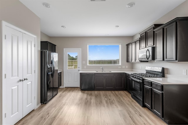 23947 Falling Daylight Dr, Hockley, TX 77447 - kitchen with black appliances, light countertops, light wood-type flooring, and a sink