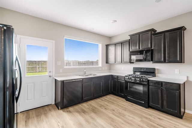 23947 Falling Daylight Dr, Hockley, TX 77447 - kitchen with black appliances, a sink, plenty of natural light, and light wood finished floors