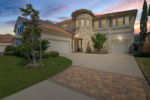 mediterranean / spanish-style house featuring stone siding, a tile roof, concrete driveway, and stucco siding