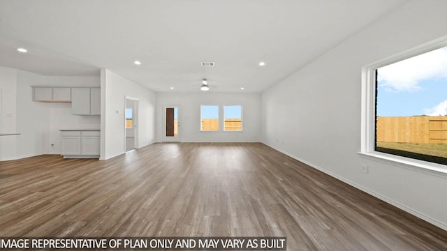 unfurnished living room with ceiling fan, recessed lighting, wood finished floors, visible vents, and baseboards