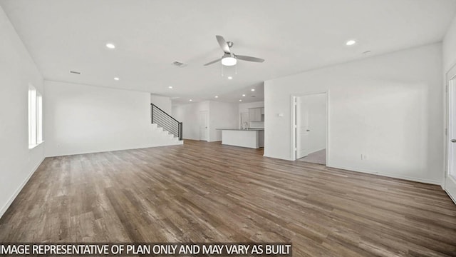 unfurnished living room with a ceiling fan, stairway, wood finished floors, and recessed lighting