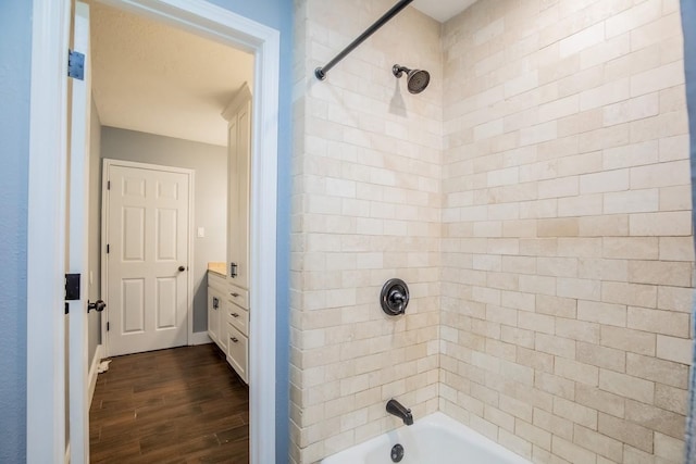 bathroom featuring wood finished floors and bathtub / shower combination