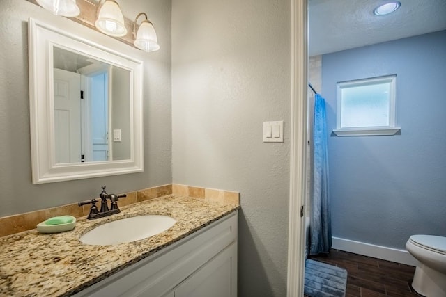 full bath featuring baseboards, wood finished floors, vanity, toilet, and a shower with shower curtain