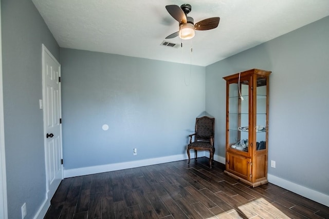 unfurnished room featuring dark wood-type flooring, baseboards, and a ceiling fan