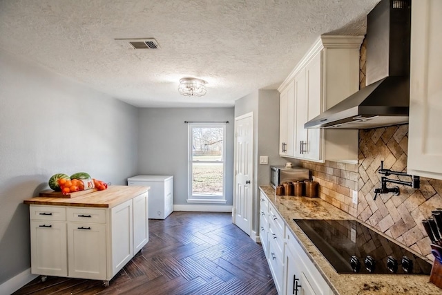 kitchen with wall chimney exhaust hood, black electric stovetop, fridge, wood counters, and tasteful backsplash