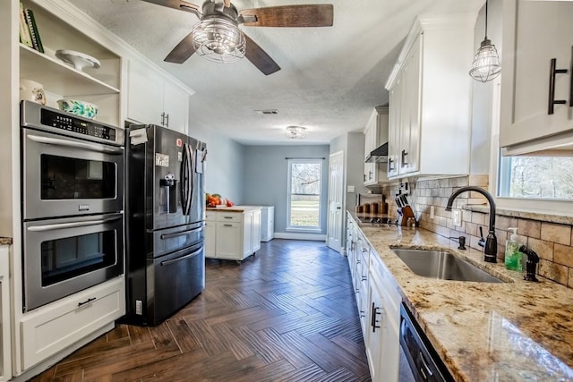 kitchen with refrigerator with ice dispenser, double oven, a sink, white cabinetry, and backsplash