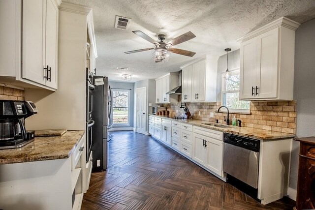 kitchen with stainless steel appliances, a sink, white cabinets, a ceiling fan, and a textured ceiling