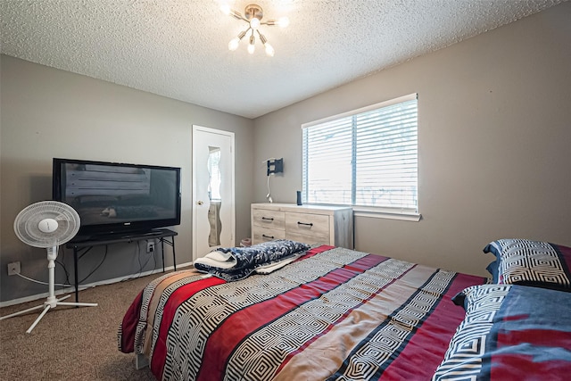 carpeted bedroom with an inviting chandelier and a textured ceiling