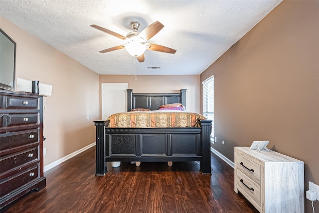 bedroom with a textured ceiling, a ceiling fan, visible vents, baseboards, and dark wood-style floors