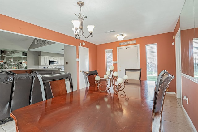 dining area featuring an inviting chandelier, baseboards, visible vents, and light tile patterned flooring