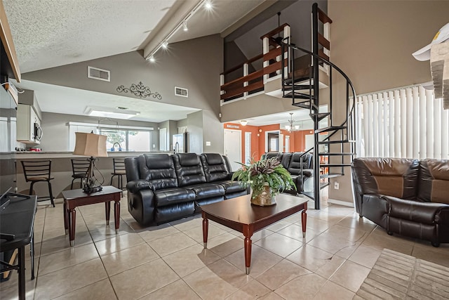 living area with lofted ceiling, light tile patterned floors, and visible vents