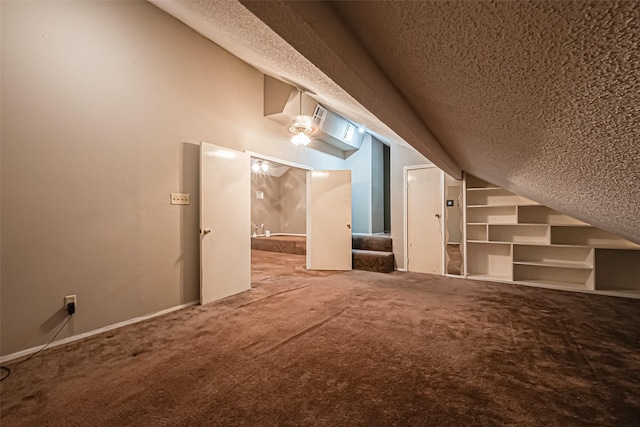 additional living space with carpet floors, stairway, and a textured ceiling