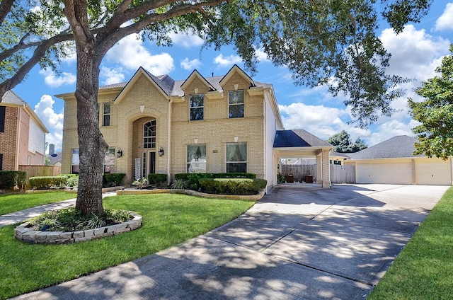 traditional-style home with brick siding, concrete driveway, a front yard, fence, and a garage