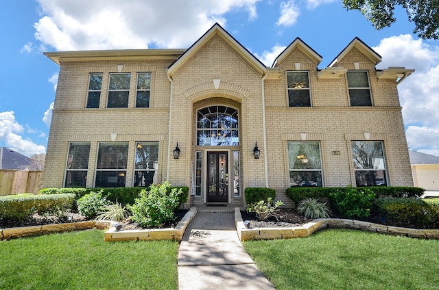 traditional home with brick siding and a front yard