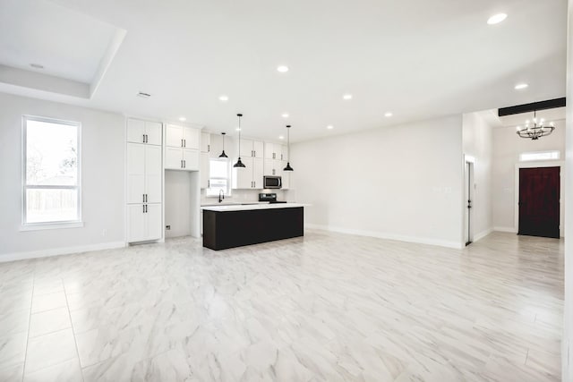 kitchen with open floor plan, light countertops, stainless steel microwave, and recessed lighting