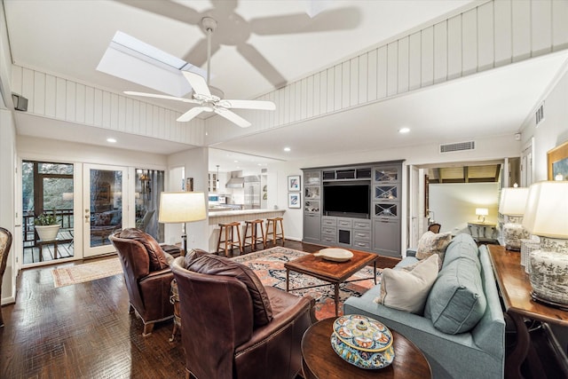 living room featuring a skylight, visible vents, dark wood finished floors, a ceiling fan, and french doors