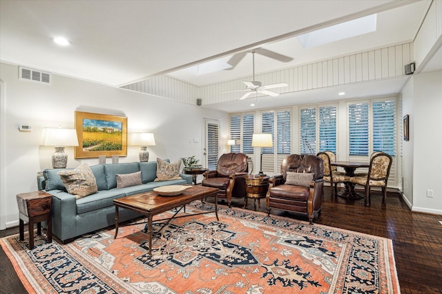 living area with ceiling fan, dark wood-style flooring, a skylight, visible vents, and baseboards