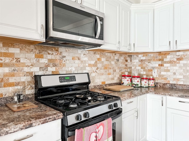 kitchen with stainless steel appliances, white cabinets, and backsplash