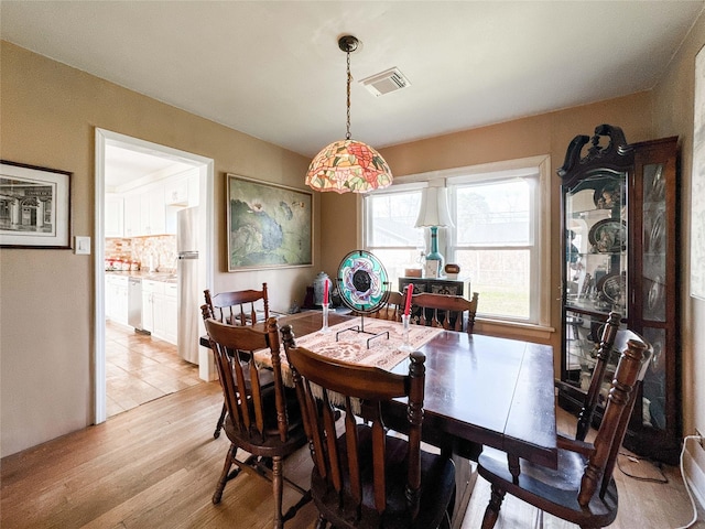 dining room with light wood-type flooring and visible vents