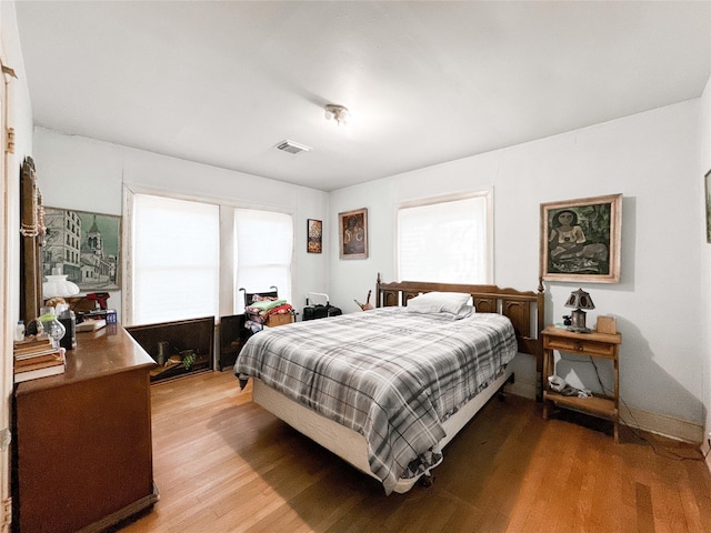 bedroom featuring light wood finished floors, multiple windows, and visible vents