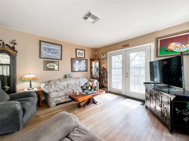 living area featuring french doors, wood finished floors, and visible vents