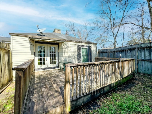 wooden terrace featuring french doors and a fenced backyard