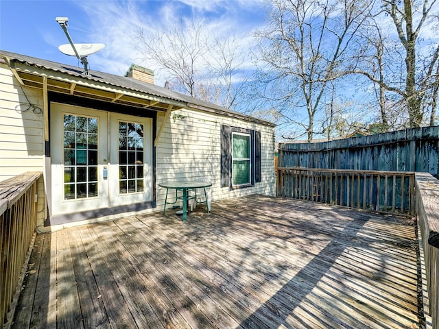 wooden terrace featuring fence and french doors