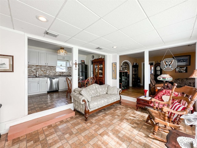 living room featuring a paneled ceiling, visible vents, and recessed lighting