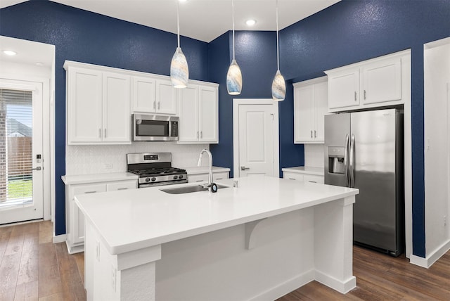 kitchen featuring stainless steel appliances, light countertops, white cabinetry, and a sink