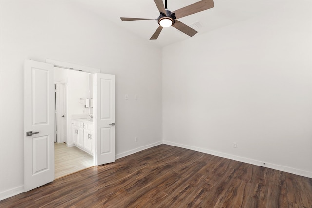 spare room featuring a ceiling fan, dark wood-style flooring, and baseboards