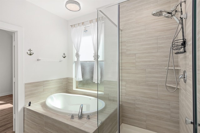 bathroom with a stall shower and a garden tub