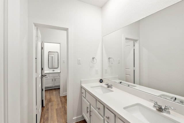 full bath with wood finished floors, a sink, and double vanity