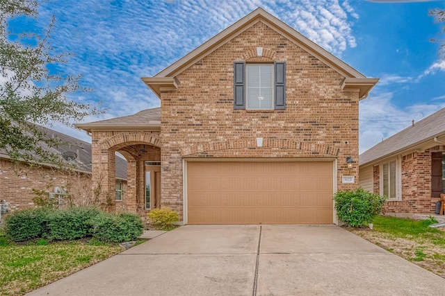 traditional home featuring a garage, concrete driveway, and brick siding