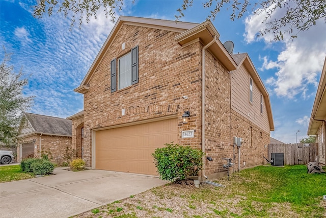 view of side of property with brick siding, driveway, an attached garage, and central AC unit