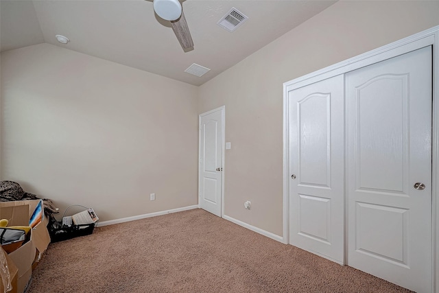 unfurnished bedroom with visible vents, baseboards, ceiling fan, carpet, and vaulted ceiling