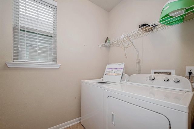 washroom featuring laundry area, baseboards, and washer and clothes dryer