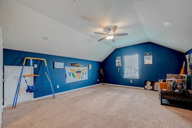 interior space with baseboards, ceiling fan, carpet, vaulted ceiling, and a textured ceiling