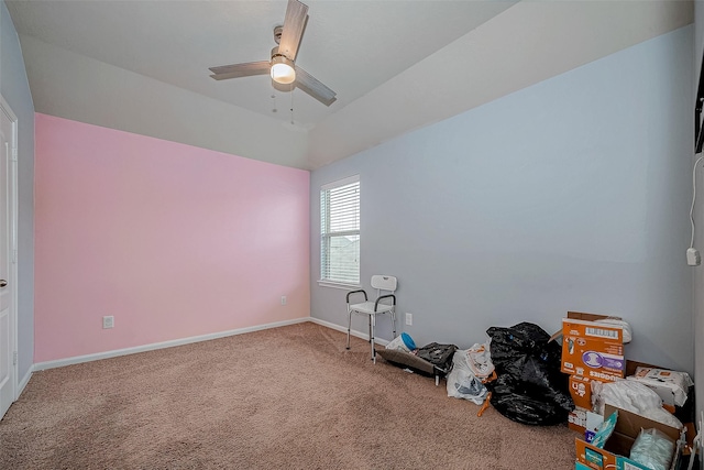 interior space featuring carpet floors, ceiling fan, baseboards, and lofted ceiling