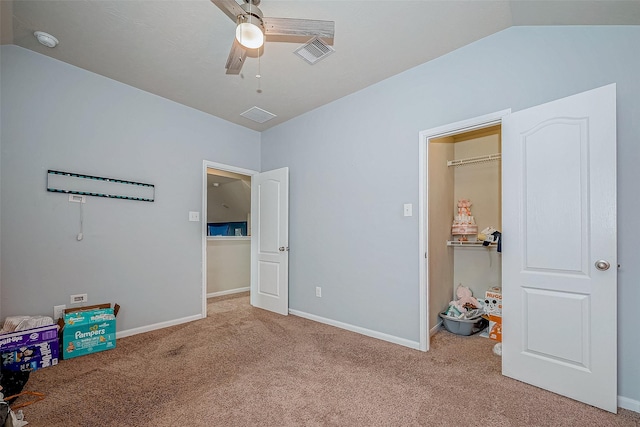 unfurnished bedroom featuring lofted ceiling, carpet flooring, a ceiling fan, visible vents, and baseboards